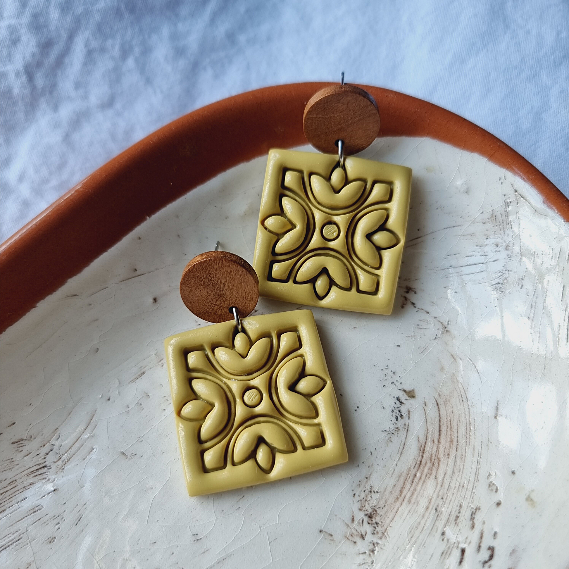Experience love in every detail with our unique handmade square embossed polymer clay drop earrings. Adorned in a stunning earthy color, these 35mm x 35mm statement pieces feature walnut wood round ear studs with stainless steel pins. 