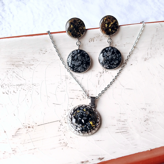 Adorn yourself with the natural beauty of Raw Snowflake Obsidian. This exquisite set includes a 20mm Round Stainless Steel necklace paired with matching 16mm Round Stainless Steel earrings,