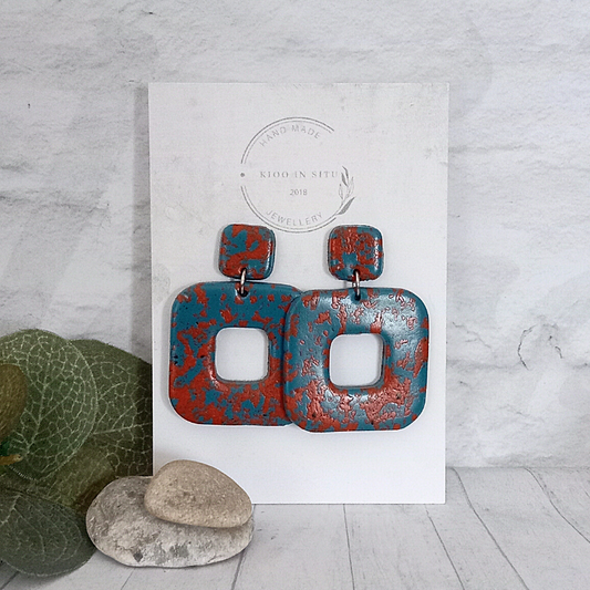 Handmade Polymer Clay Earrings – a stylish and unique addition to your jewelry collection. These square-shaped earrings feature a captivating blend of blue and terracotta colors, making them a perfect choice to complement various outfits.