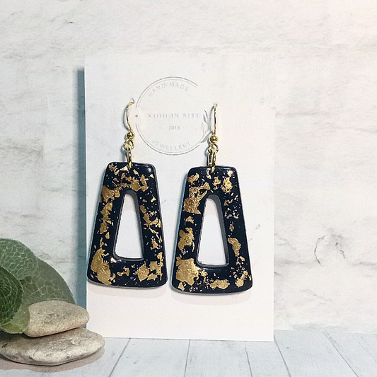 Unique handmade polymer clay earrings, a perfect blend of sophistication and individuality. These striking earrings feature a sleek black base adorned with delicate golden leaf accents,