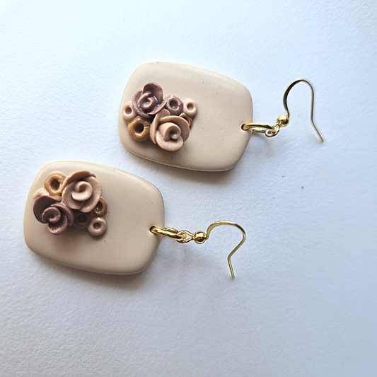 Exquisite handmade polymer clay earrings. These elegant earrings feature a sophisticated beige square shape adorned with delicate handmade roses, adding a touch of natural charm to your look. 