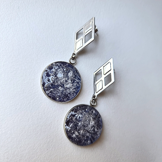 These unique, handmade Clear Quartz Drop Earrings are made of raw quartz crystals set in stainless steel 20mm rounds, with a dark blue background for eye-catching contrast.