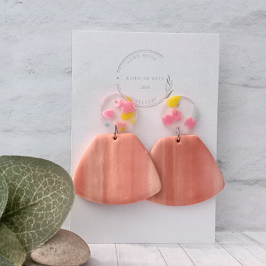 These Polymer Clay Earrings are one of a kind! Adorn your ears with these stylish Salm pink polymer clay pieces that sit delicately on the Perspex round 15 mm ear studs