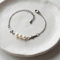 Handmade white freshwater pearl bracelet with three natural pearls, stainless steel crosses and cable chain.