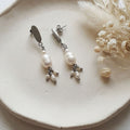 White freshwater pearl dangle earrings with 6mm centre pearl, rice pearl accents and stainless steel oval studs