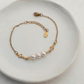 Handmade white freshwater pearl bracelet with three natural pearls, gold-plated stainless steel crosses and cable chain.