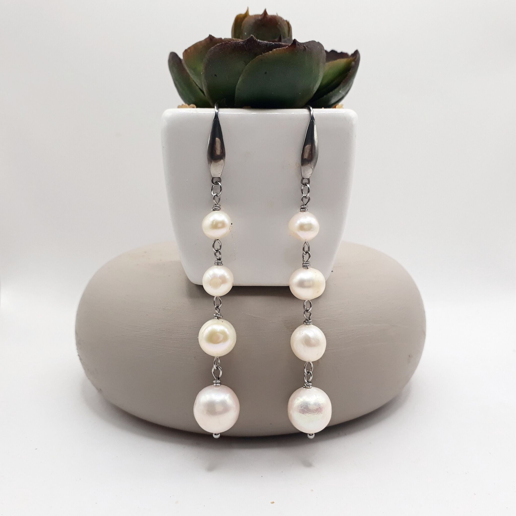 Handcrafted freshwater pearl dangle earrings feature an elegant cascading design made from four natural white freshwater pearls