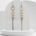 Handmade white freshwater pearl dangle earrings with stainless steel circle and bar design