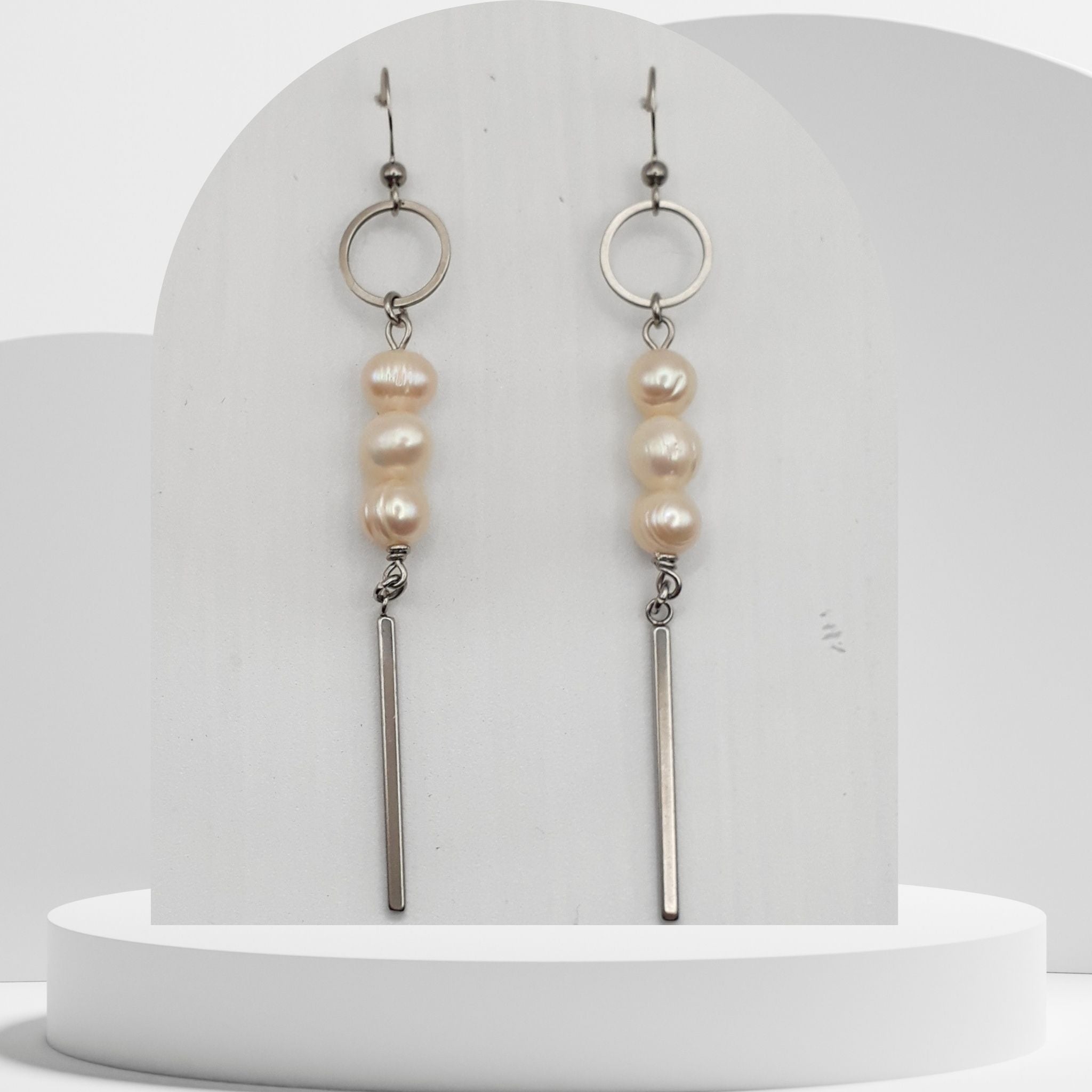 Handmade white freshwater pearl dangle earrings with stainless steel circle and bar design