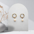 Handmade 316L gold-plated stainless steel 16 mm huggie hoop earrings with removable 7 mm natural white freshwater pearls and white rice pearl charms.