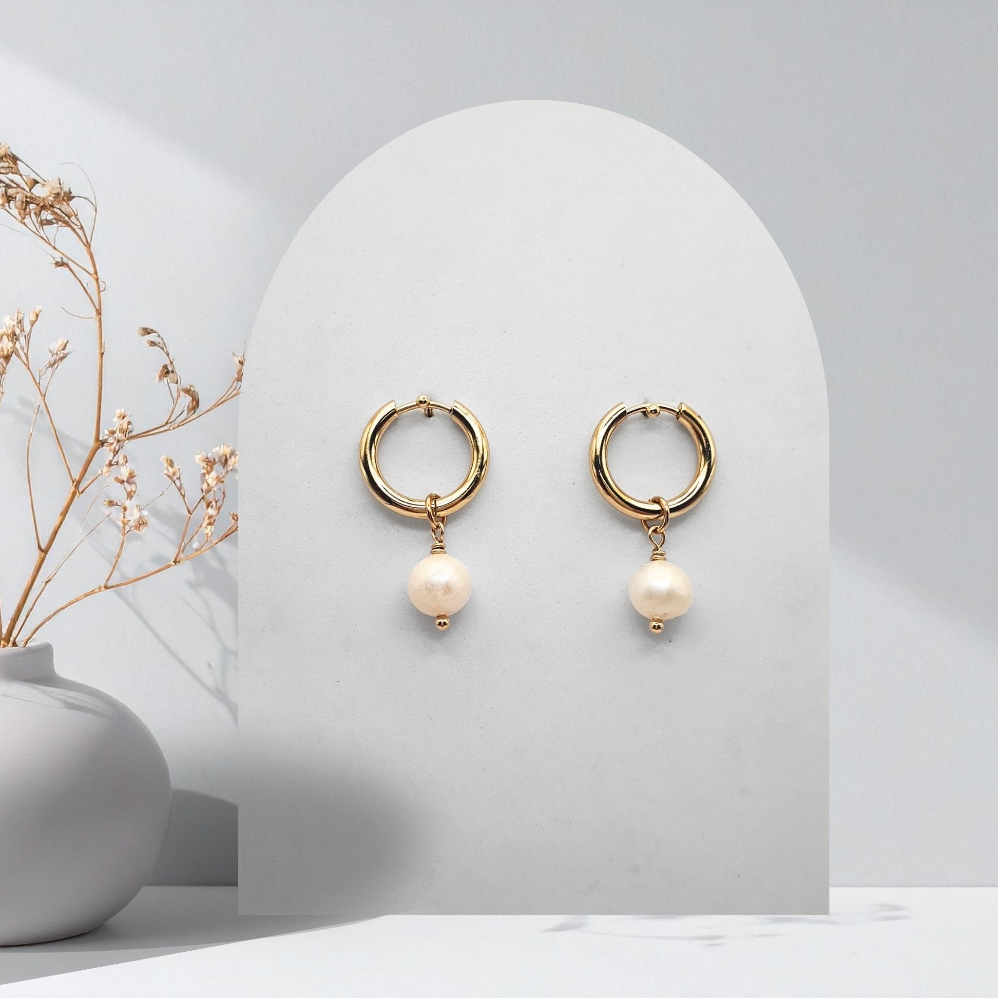 Handmade 316L gold-plated stainless steel 16 mm huggie hoop earrings with removable 7 mm natural white freshwater pearls and white rice pearl charms.